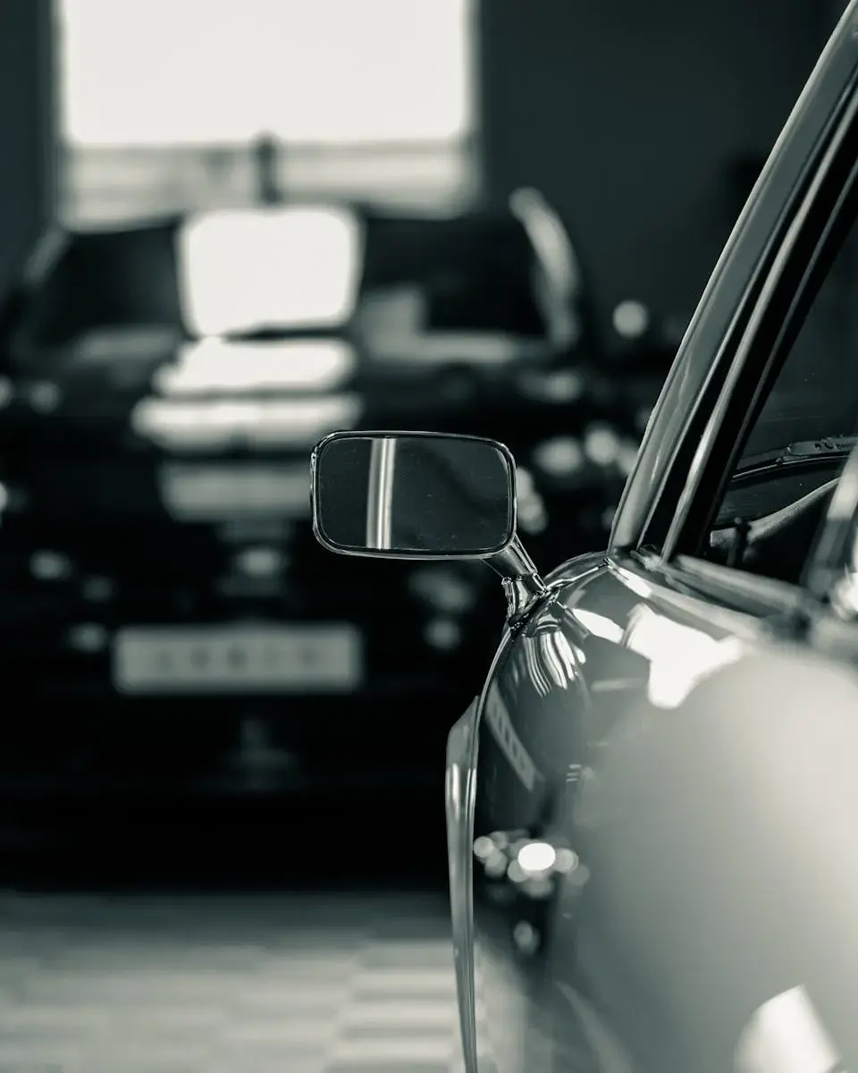 A close-up shot of a classic car's side mirror, exuding elegance and style in a monochrome setting.
